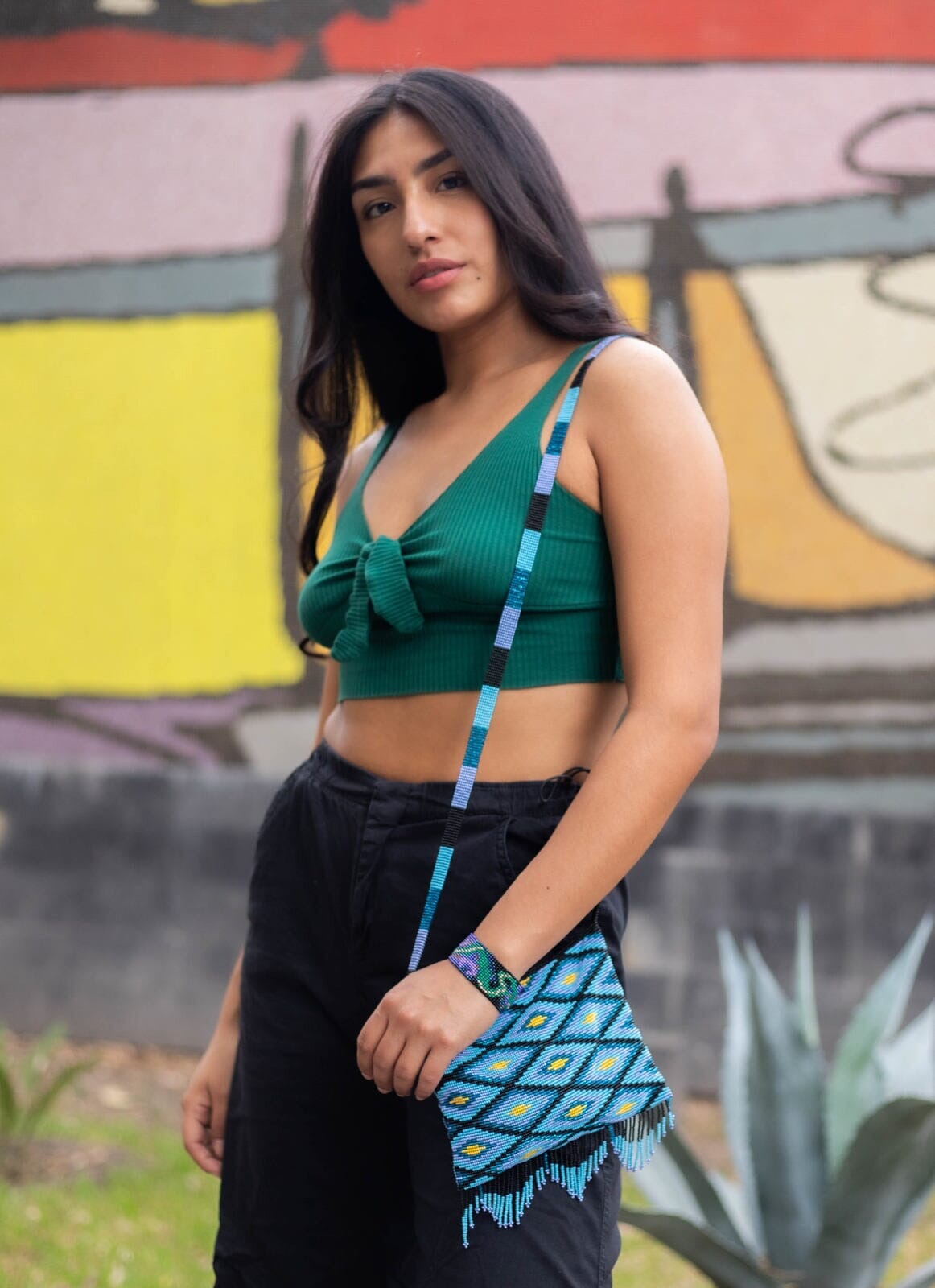 woman wearing blue yellow black diamond beaded purse bag fringe