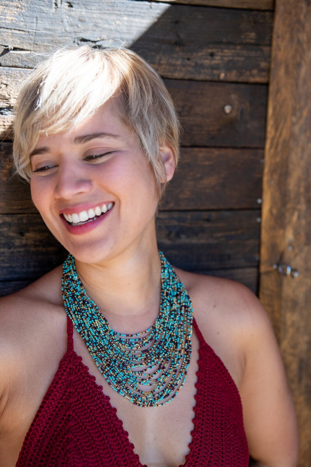 A woman in Blue Pebbles beaded multi-strand Necklace, turquoise, black, gold Native American jewelry from Mother Sierra.