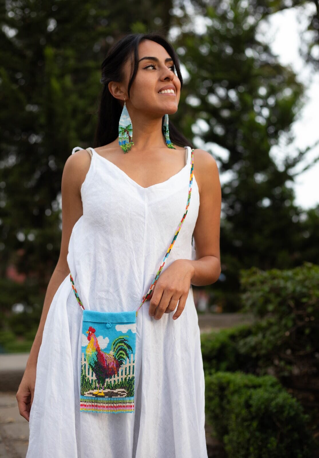 woman wearing burrito gallo rooster beaded purse shoulder bag Blue, White, Red, Yellow, Green, Pink fringe in white dress