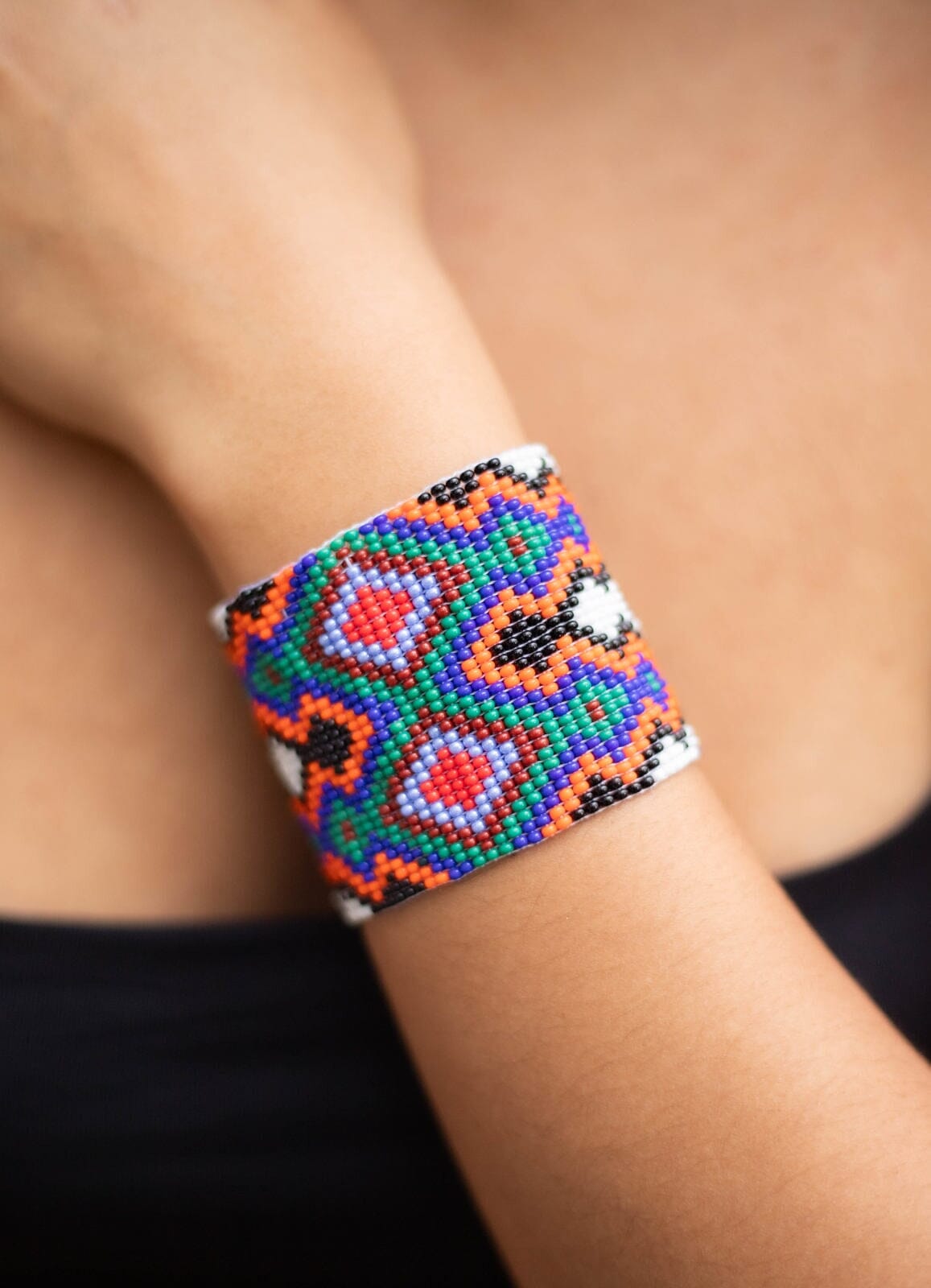 close up woman wearing Far Out White, Yellow, Orange, Blue, Green, Red, Purple beaded bracelet cuff