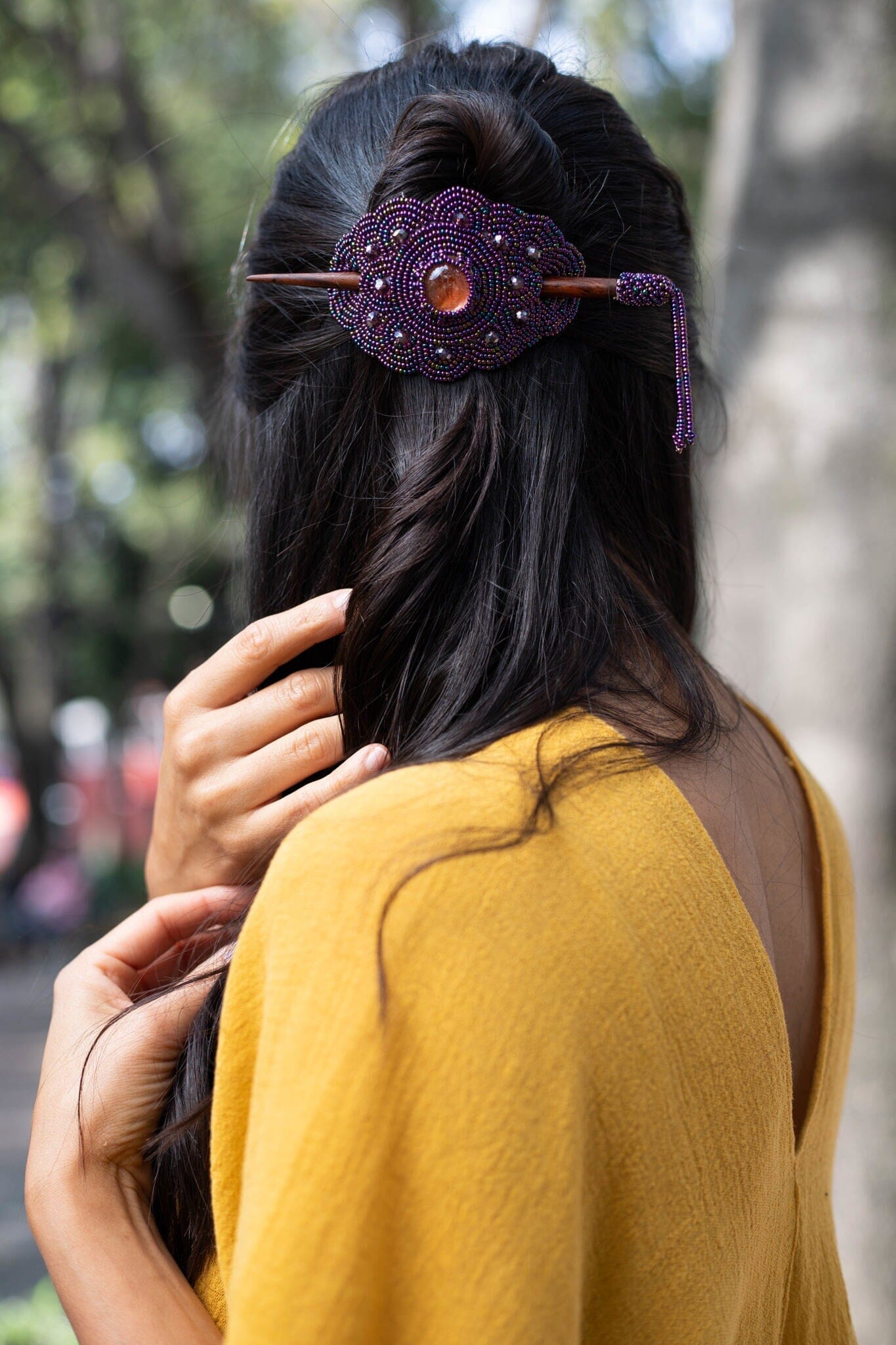 woman wearing holly berry purple beaded hair barrette and pin statement piece native american jewelry