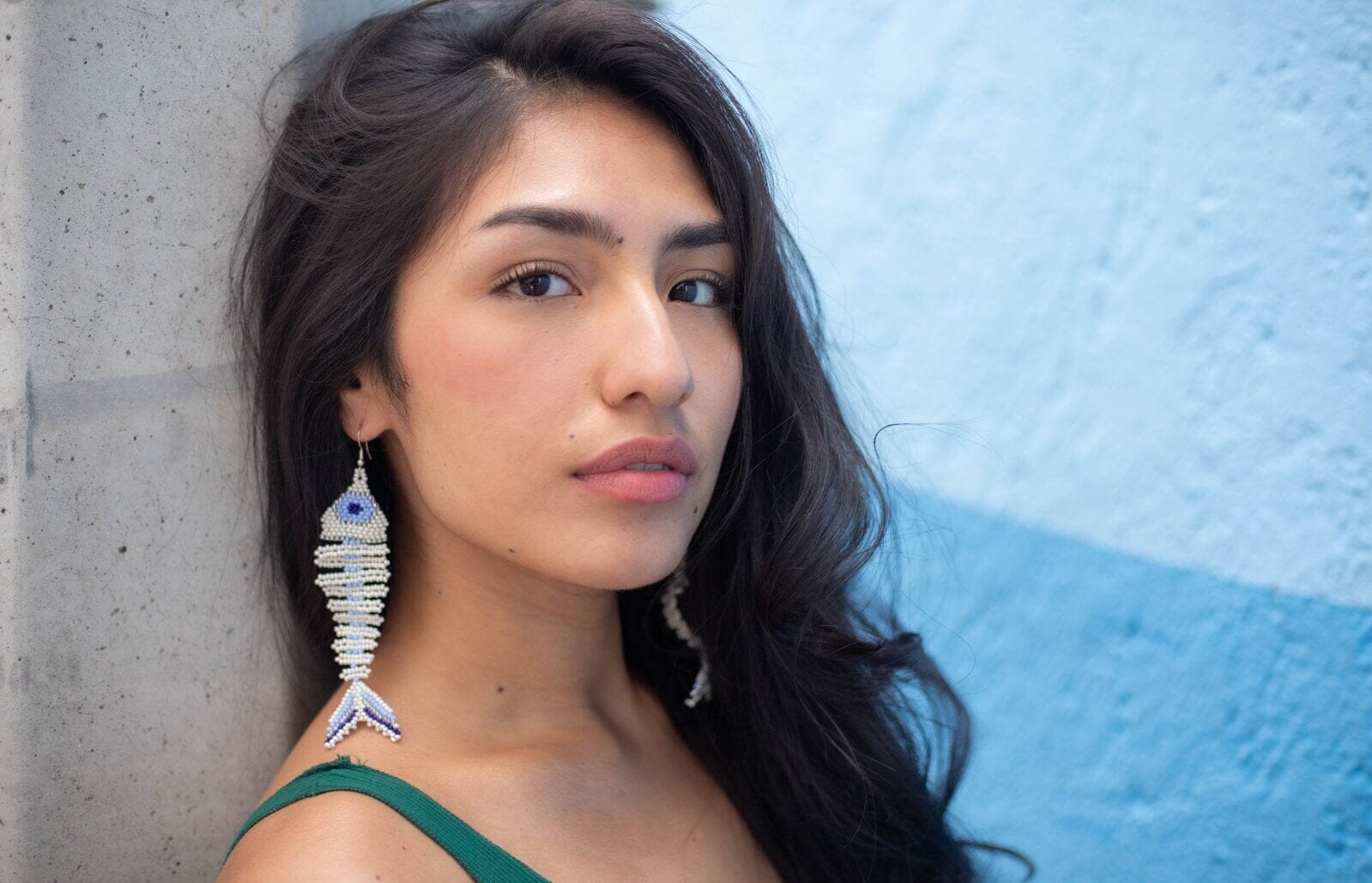 woman wearing Pearl Of The Nile soft blue fish skeleton fossil beaded earrings