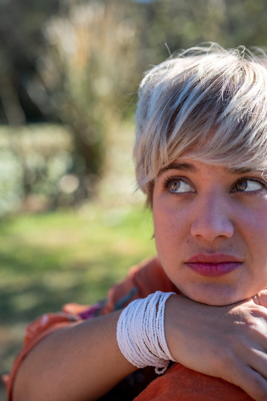 A woman wearing a handmade White Whisperer beaded bracelet, a multi-strand cuff featuring native American jewelry by Mother Sierra.