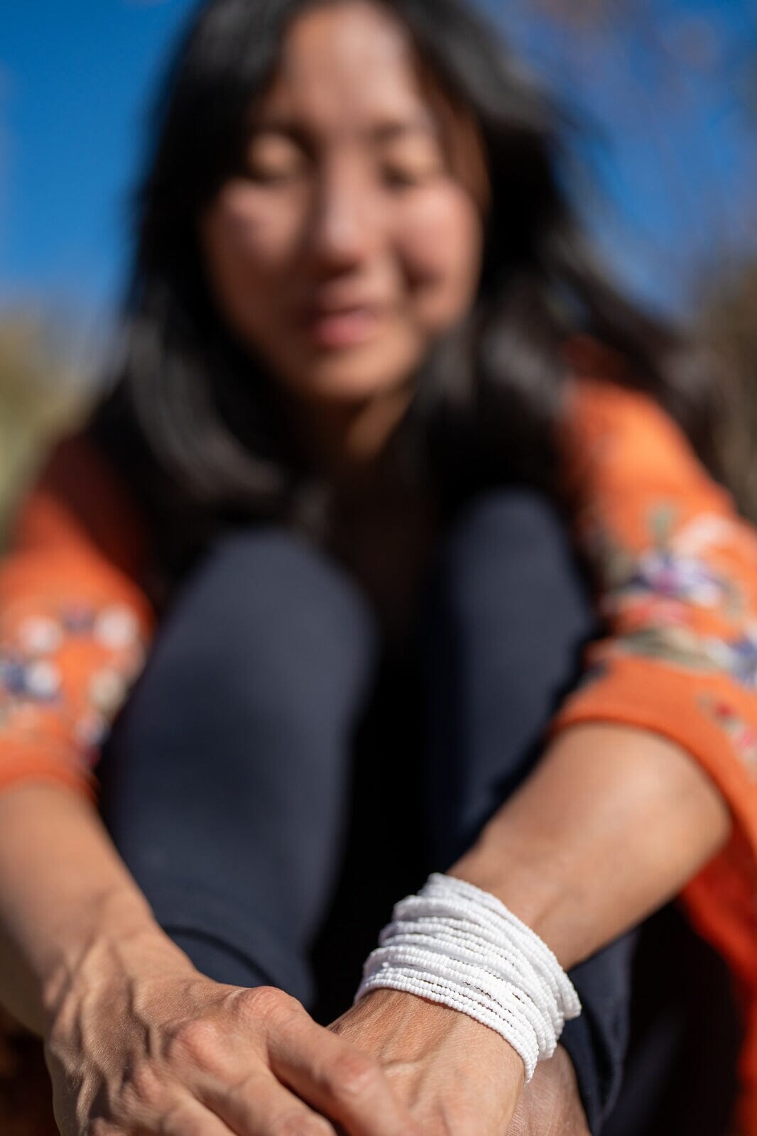 Woman wearing White Whisperer handmade beaded bracelet from Mother Sierra.