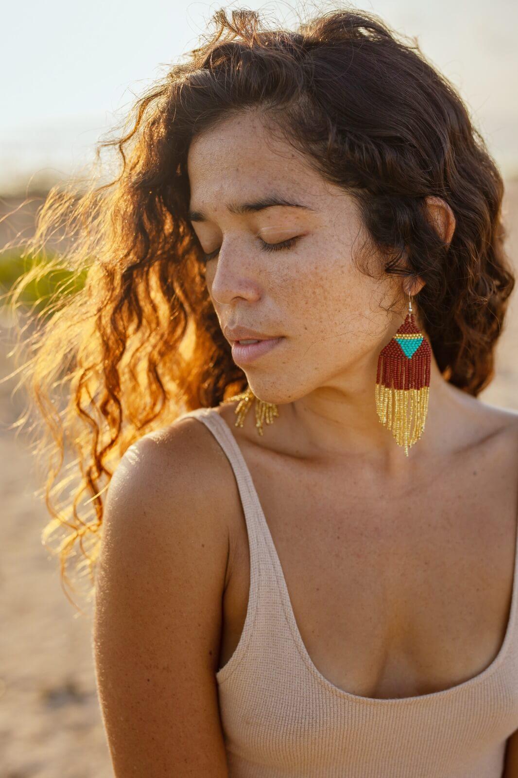 woman wearing brown gold blue pyramid fringe beaded earrings