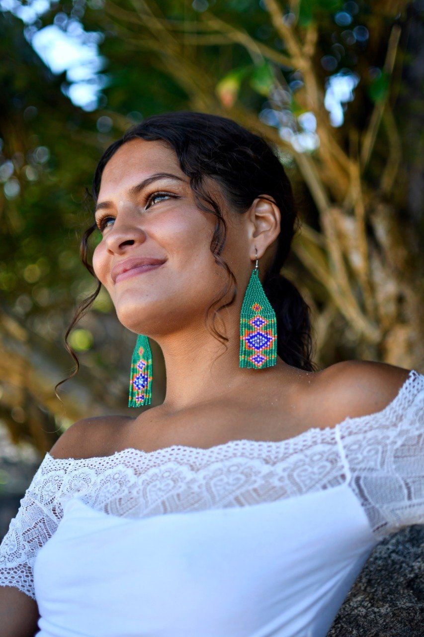 woman wearing green purple ayin harah fringe beaded earrings