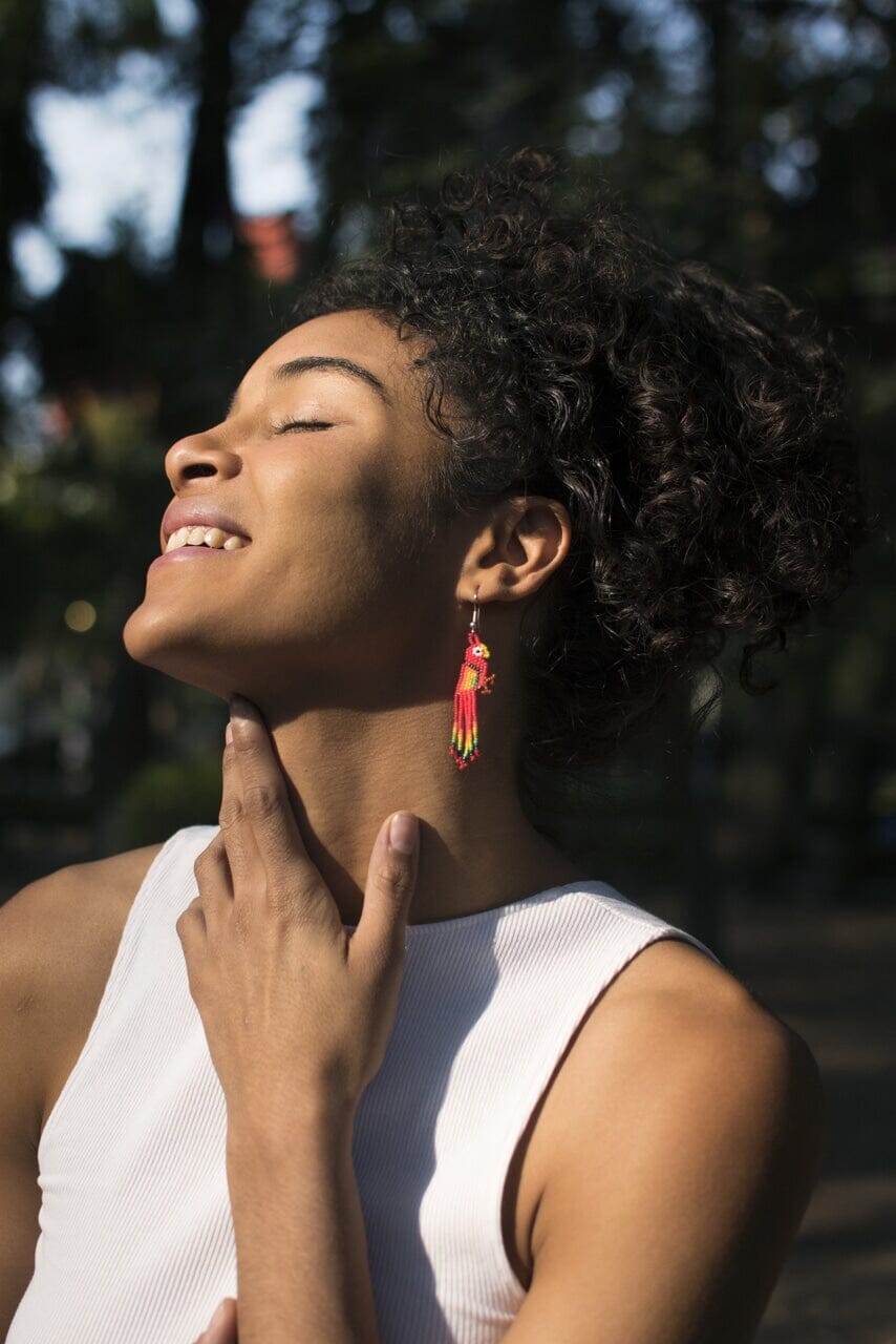 woman wearing red fire bird beaded earrings