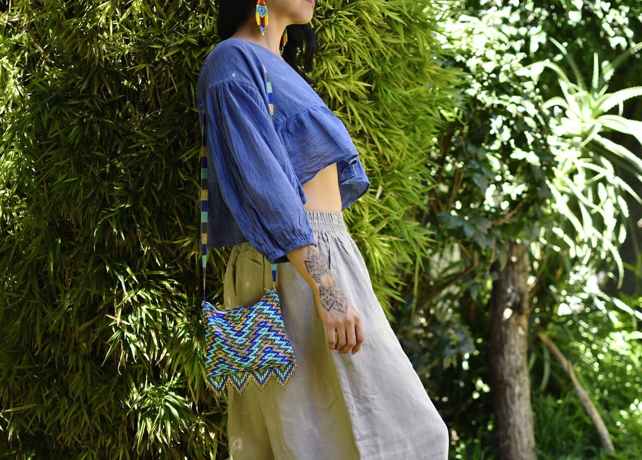 woman wearing teal blue gold high tide beaded purse bag fringe