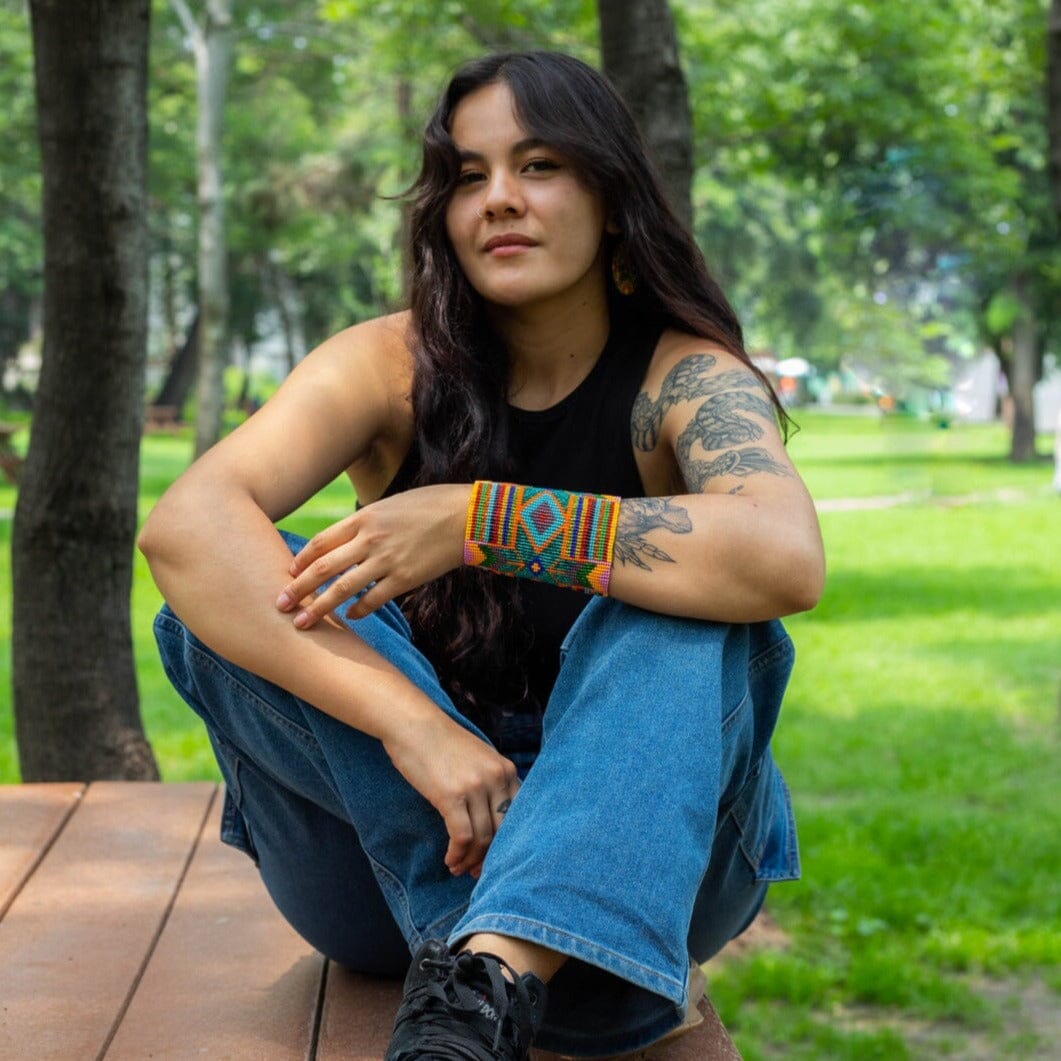 woman wearing Moroccan Medley Super Nova orange gold red blue pink beaded bracelet wide cuff