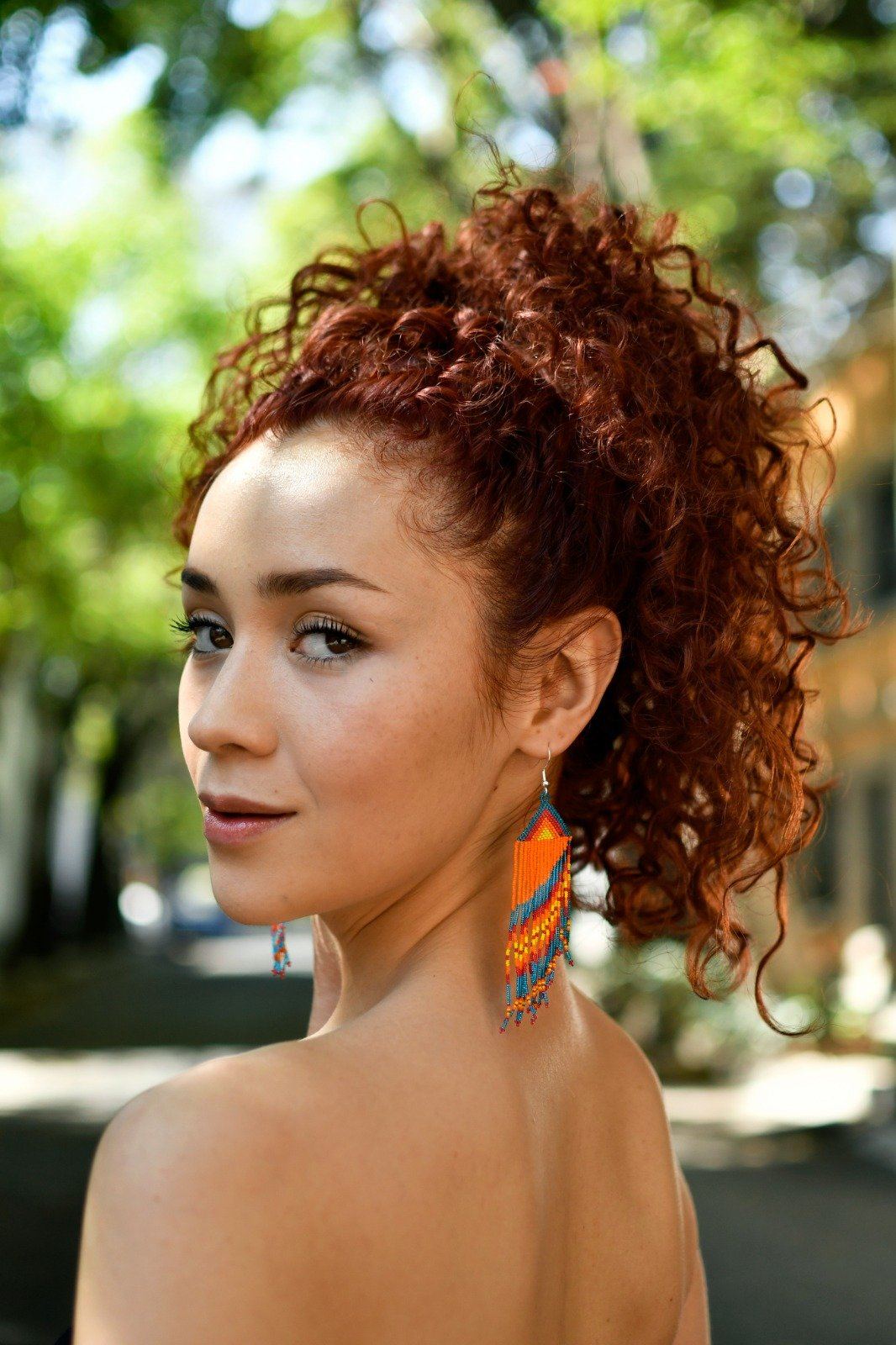 woman wearing blue orange red yellow parrot tail micro fringe beaded earrings