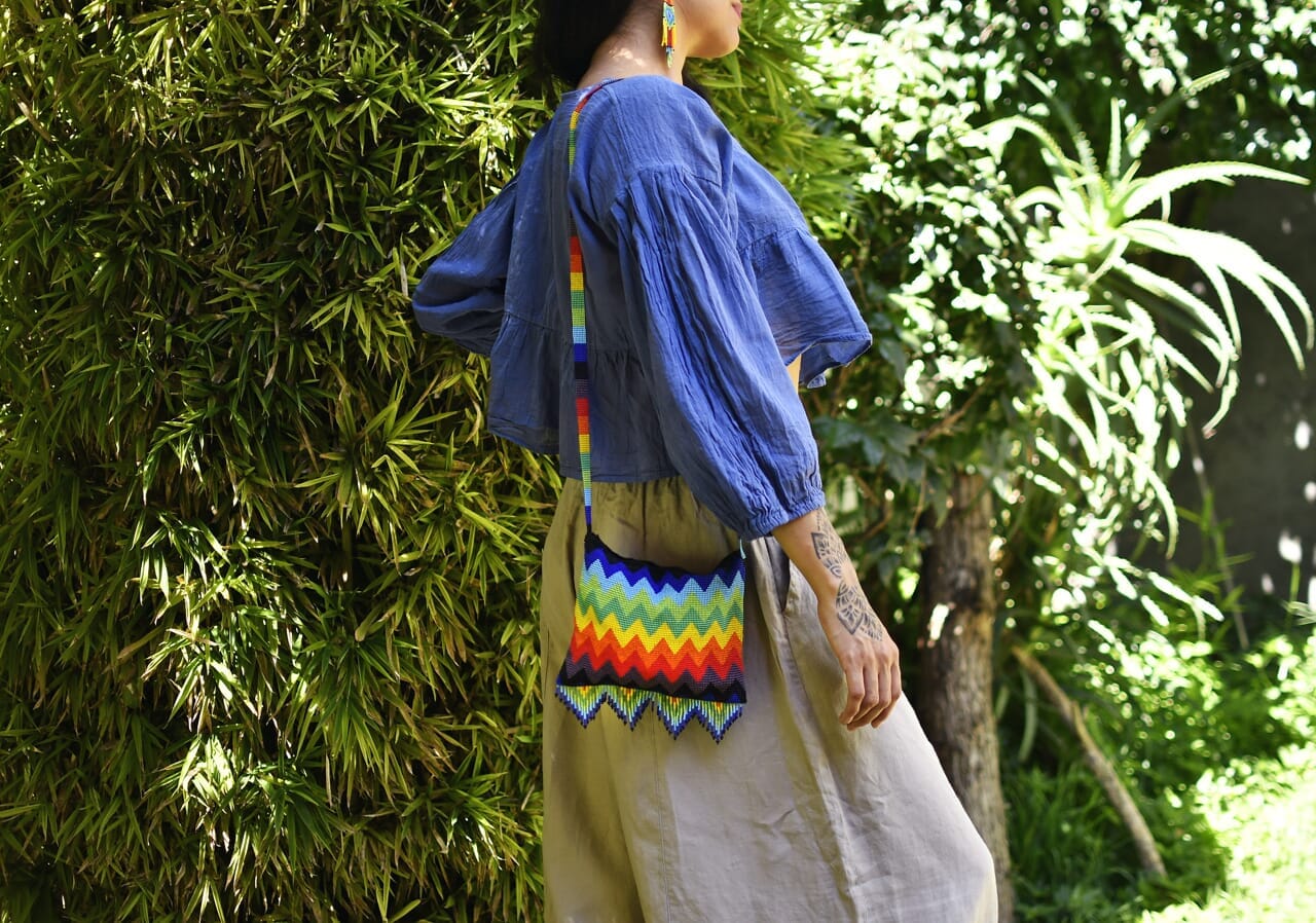 woman wearing rainbow frenzy red orange yellow green blue beaded purse bag fringe