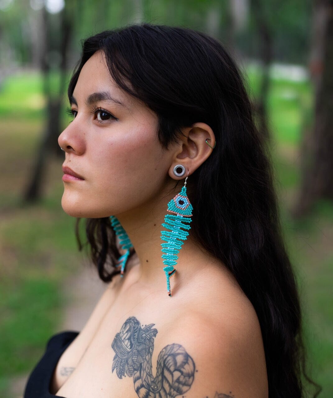 woman wearing Tetra cyan fish skeleton fossil beaded earrings