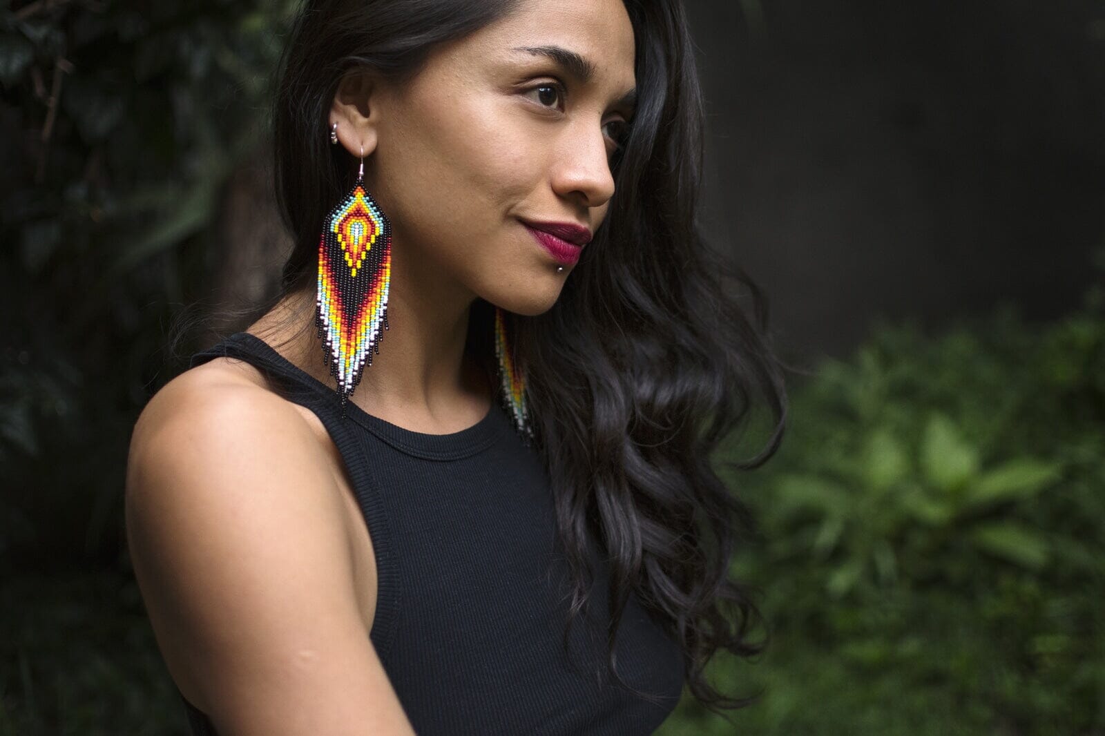 woman wearing black fire teal white red icy hot fringe beaded earrings