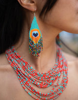 woman wearing arriba multi-strand beaded necklaces red blue native american jewelry and pavo real earrings