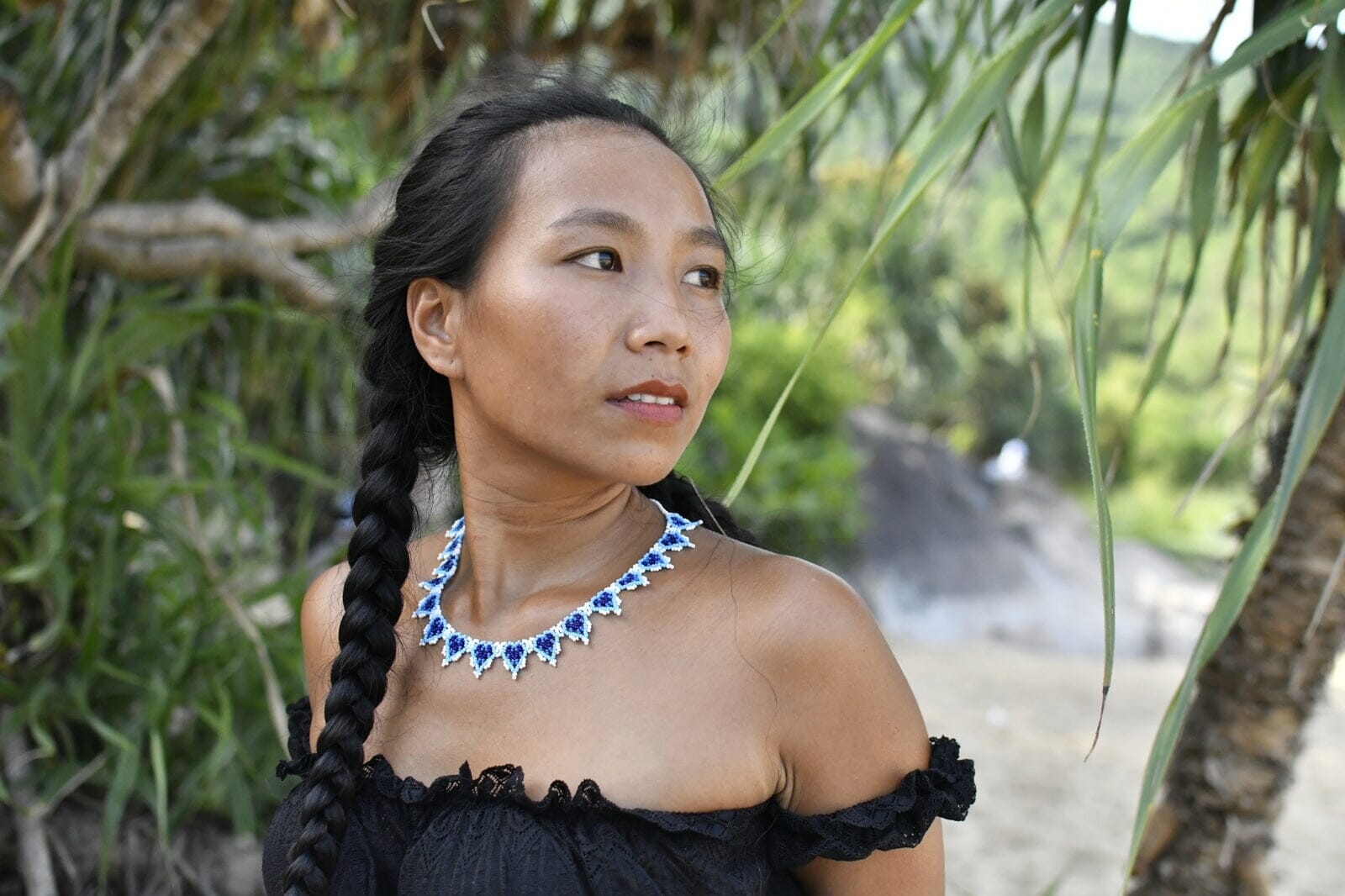 A woman wearing blueberries blue white handmade beaded necklace native american jewelry