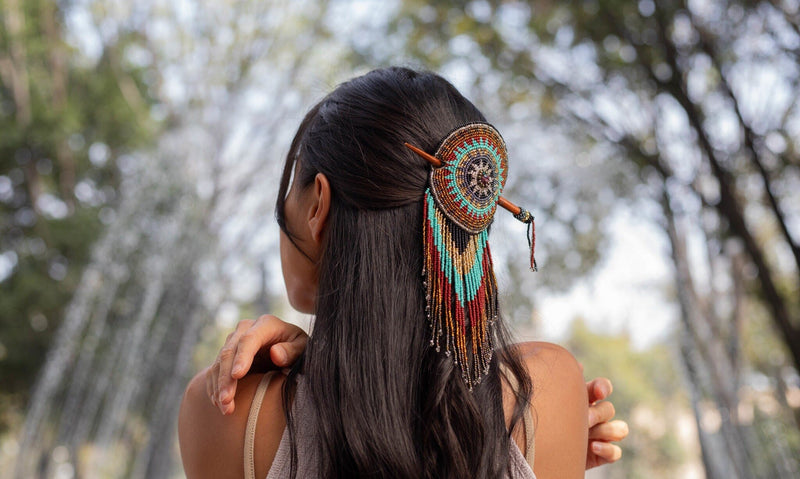 woman wearing tiara round blue gold brown beaded hair barrette and pin statement piece native american jewelry