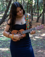 woman wearing Broken Arrow beaded Guitar Strap rainbow red blue green yellow white black adjustable leather on guitar on ukulele in forest