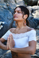 woman meditating praying wearing brown white chocolate skull fringe beaded earrings dia de los muertos