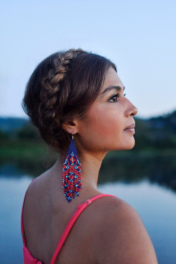 woman wearing blue and red chiapas fringe beaded earrings at dusk