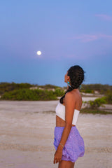 woman outdoors looking at moon at dusk wearing blue black white micro fringe beaded earrings