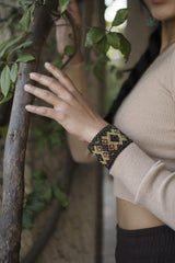 woman wearing Grecian Gold mosaic black gold beaded bracelet cuff in forest