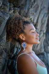 woman wearing Guanábana light blue eggshell white beaded earrings against rock wall
