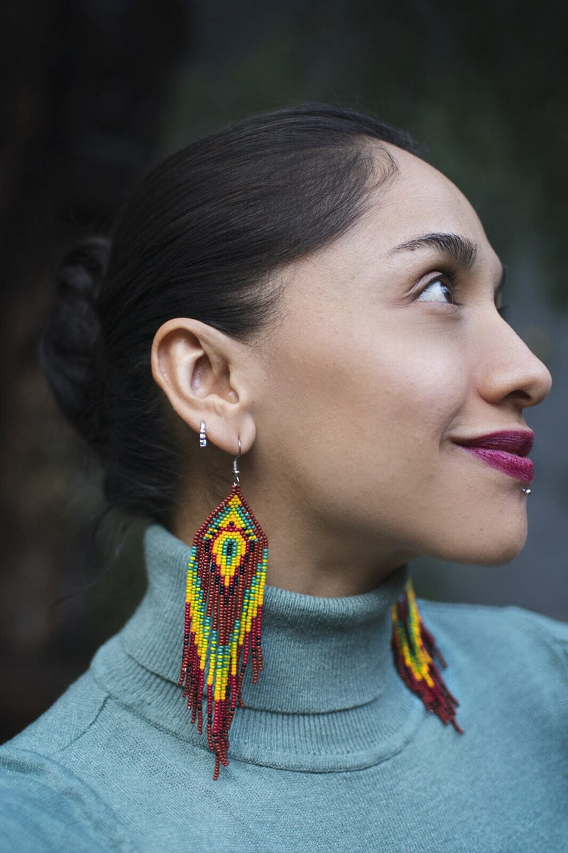 woman wearing brown red green yellow rainforest fringe beaded earrings side view