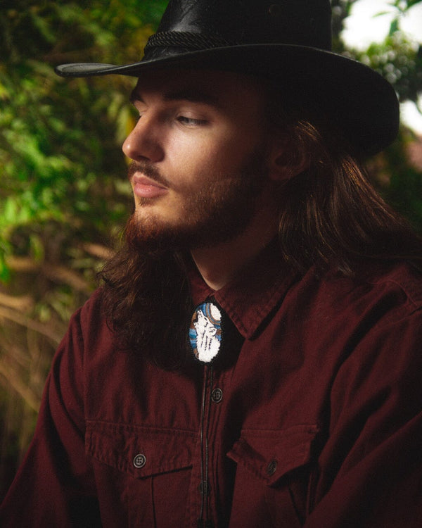 man wearing lobo wolf blue jasper white black embroidered beaded Bolo Tie necklace necktie native american jewelry