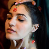 woman wearing red pink green flower dangle beaded earrings