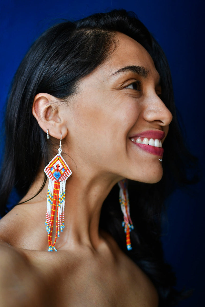 woman wearing red white blue fox native american fringe beaded earrings side view