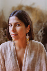 woman wearing white yellow brown red hawktail micro fringe beaded earrings