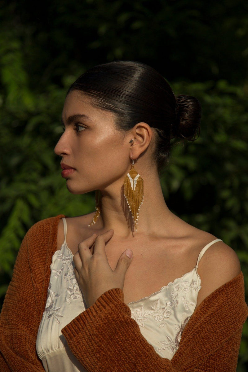 woman wearing gold white micro fringe beaded earrings