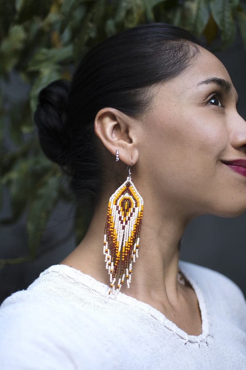 woman wearing sandy white brown yellow fringe beaded earrings side view