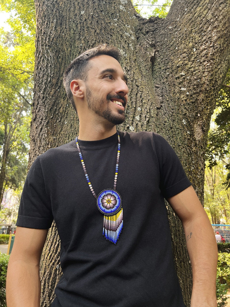 man wearing wind blue yellow white gray black beaded necklace medicine bag fringe native american jewelry